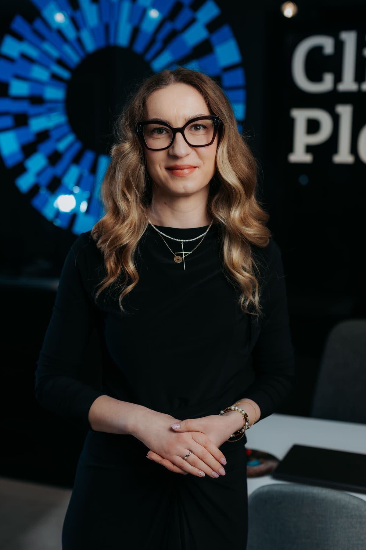 Medic din echipa Platinum Optic, portret în halat alb pe fundalul cu logo-ul clinicii