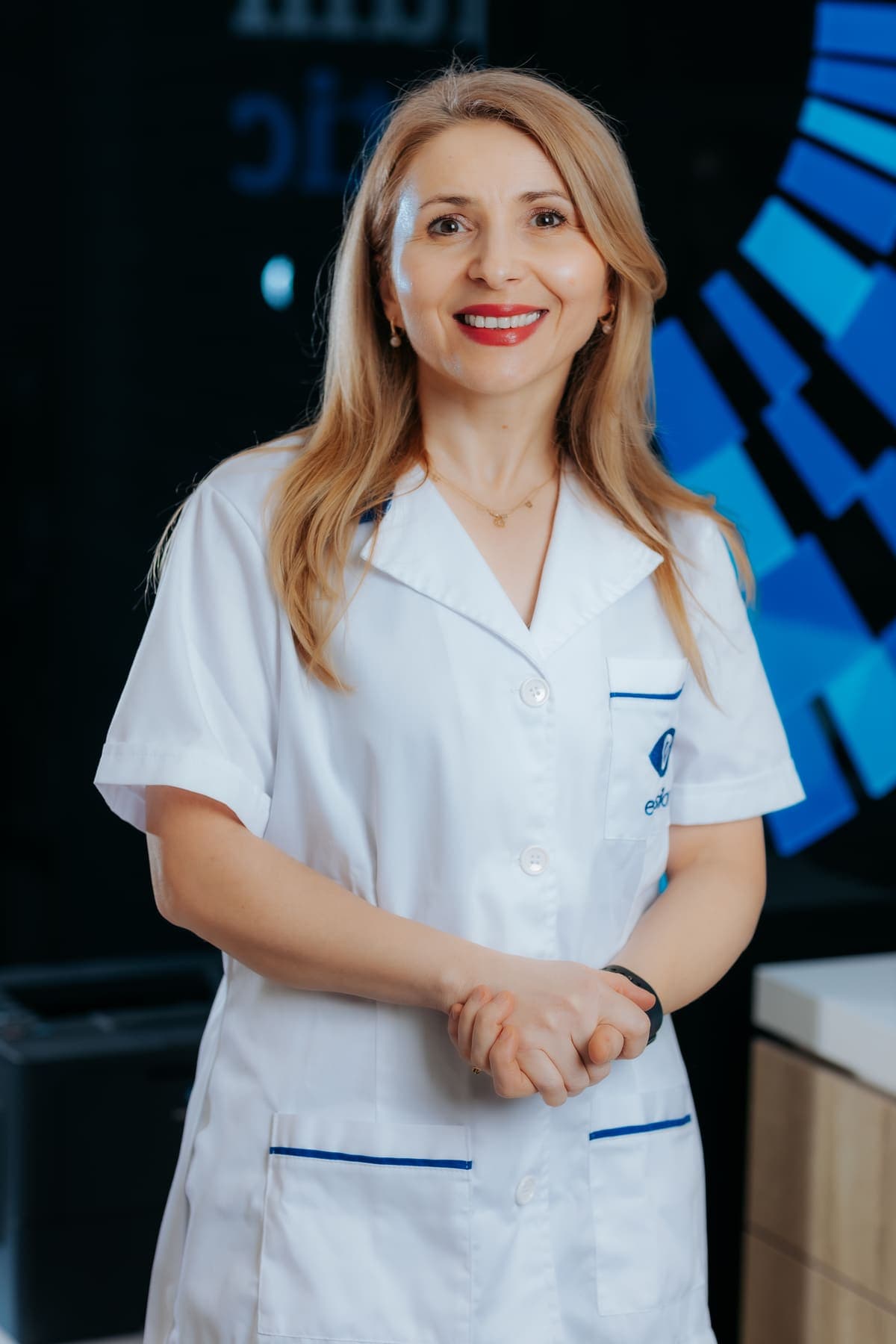 Membru al echipei Platinum Optic, portret pe fundalul cu logo-ul clinicii