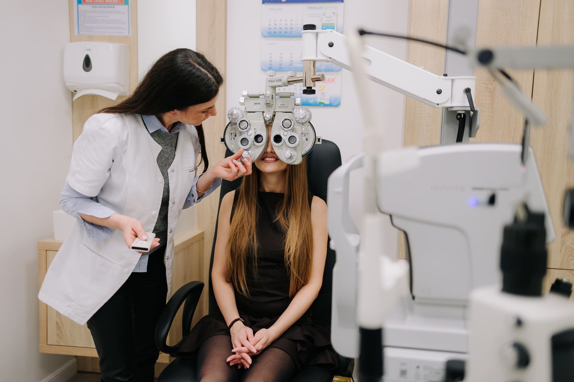 Medic oftalmolog Platinum Optic consultând o pacientă tânără la biomicroscop