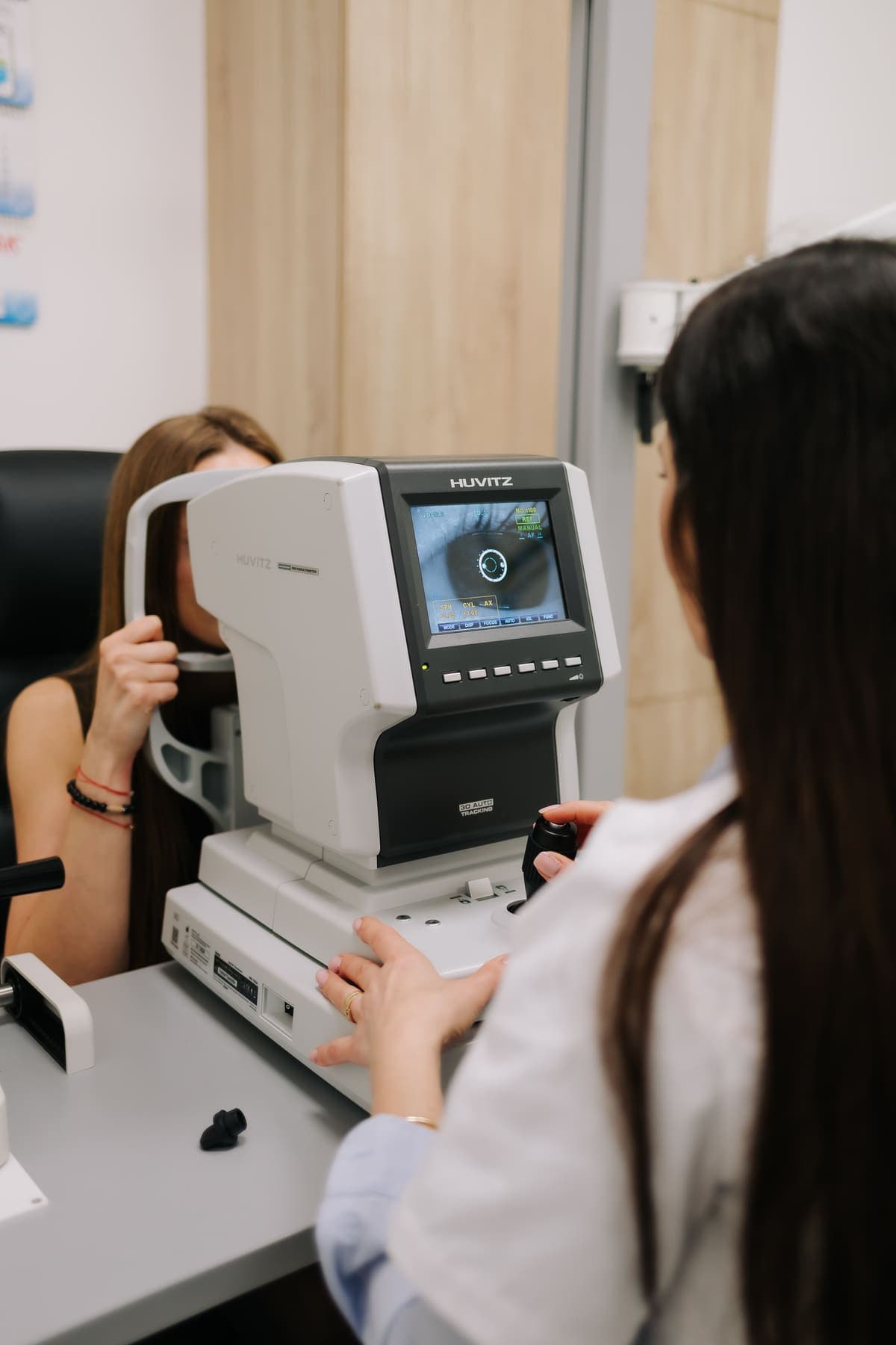 Optometrist Platinum Optic determinând corecția unui pacient la autorefractometru