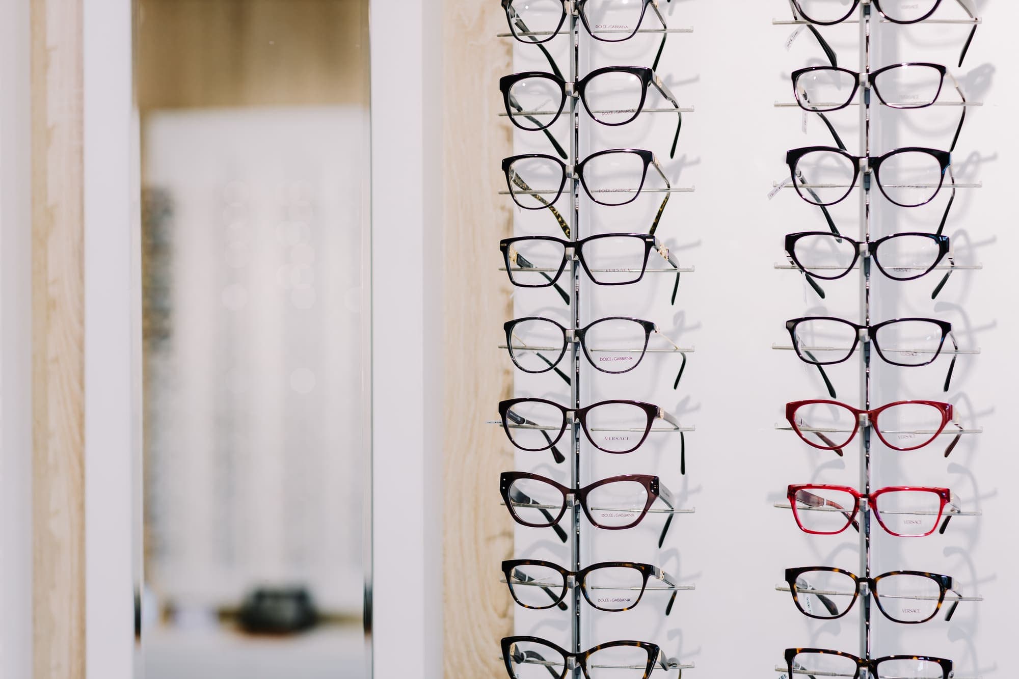 Rânduri de rame aliniate pe suporturile din showroom-ul Platinum Optic